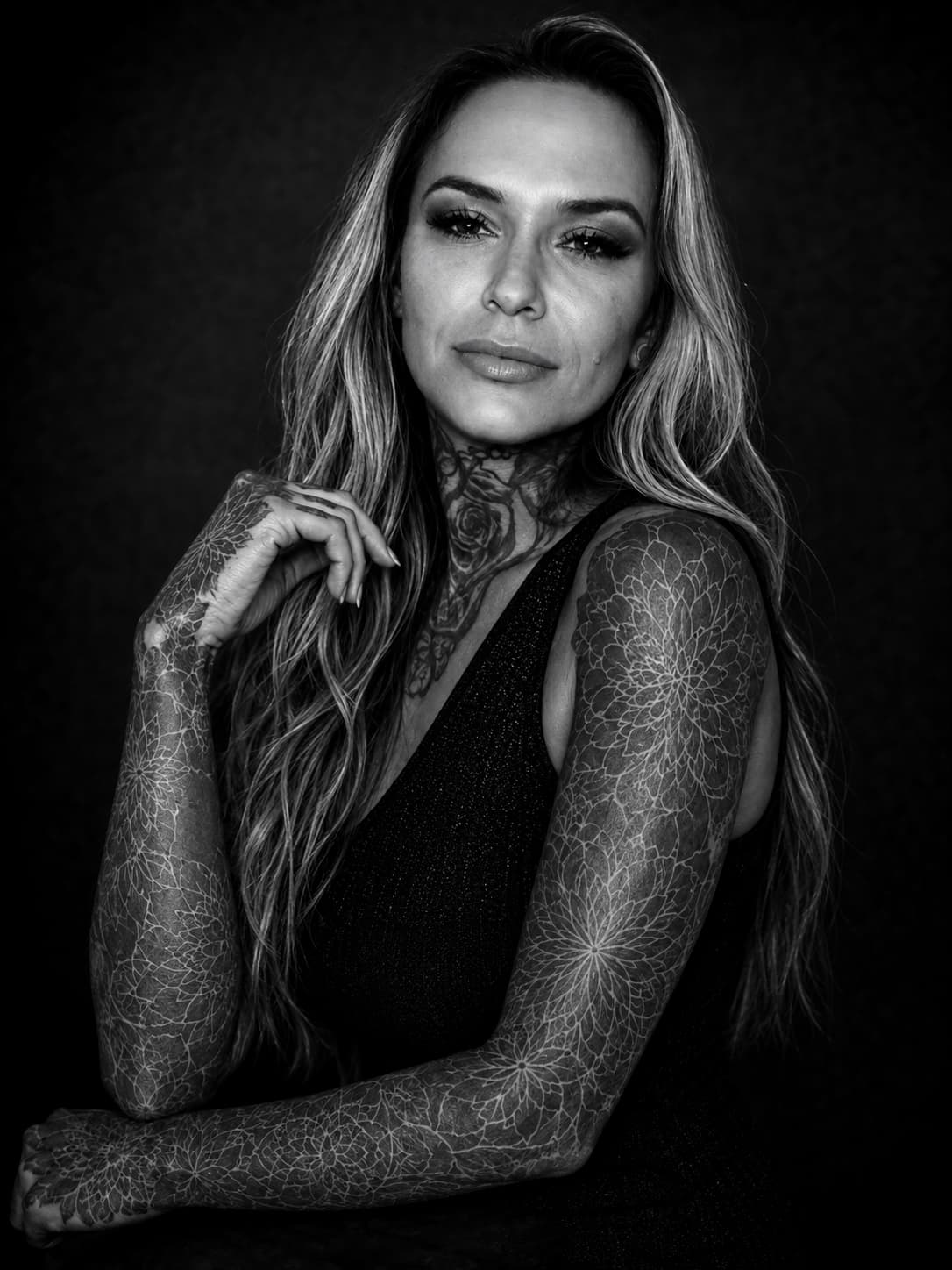 Amber Adames seated, the mandala sleeves on both arms in full view